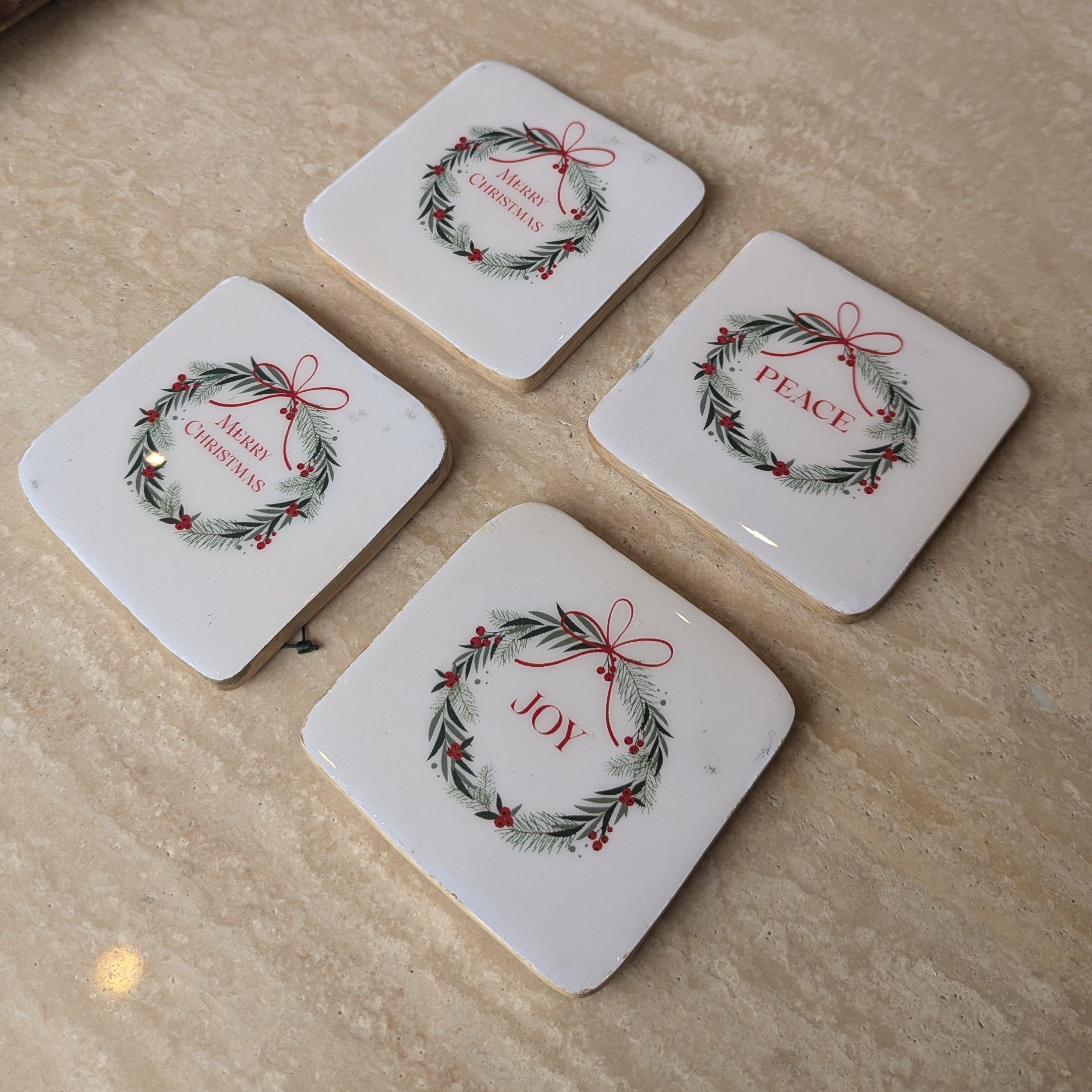 Set of 4 christmas coasters with wreath design and christmas sayings.