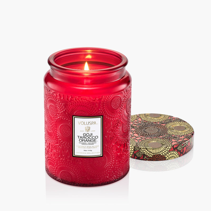 Red candle jar with decorative lid on a white background