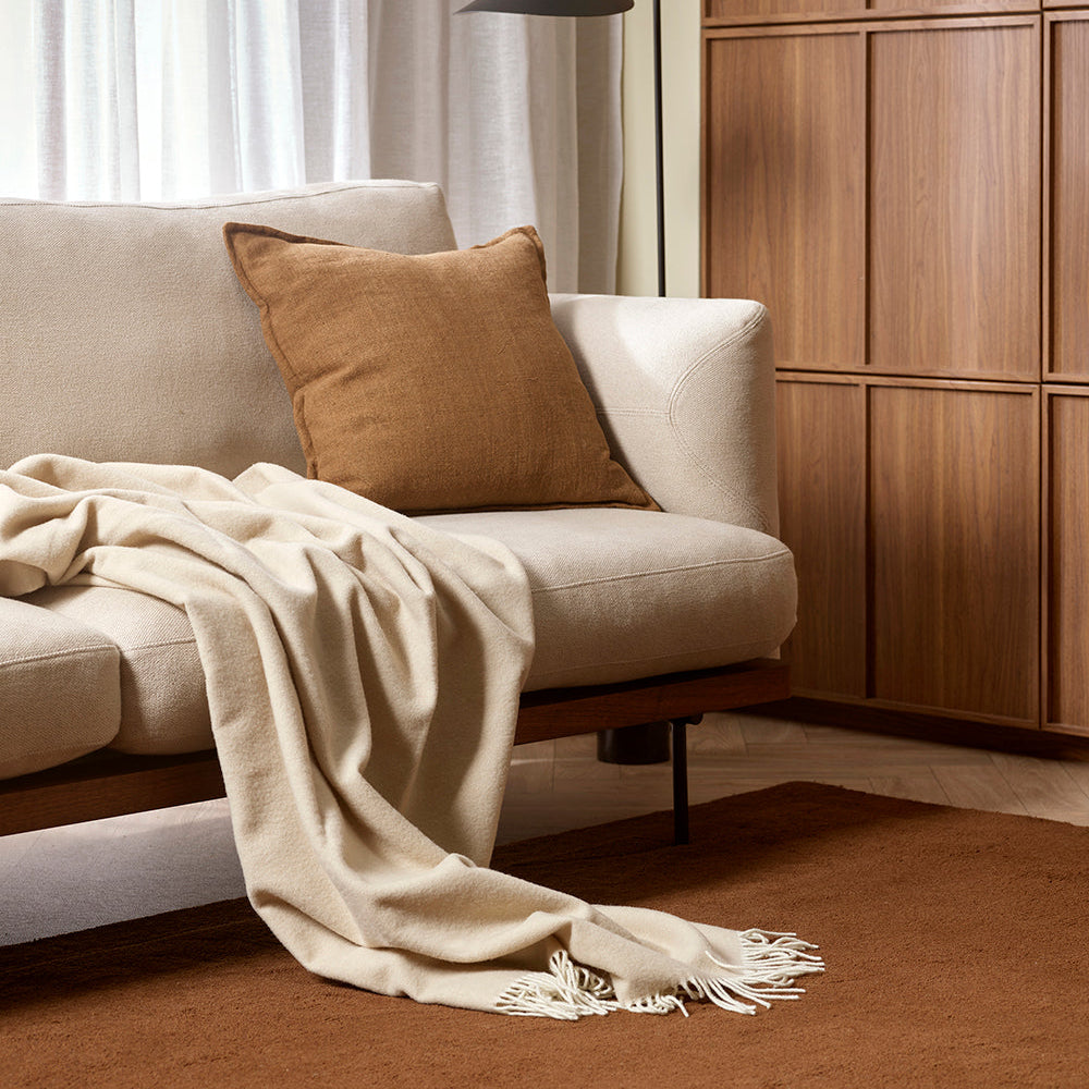 Merino wool blanket throw by Baya in Oyster shade on sofa
